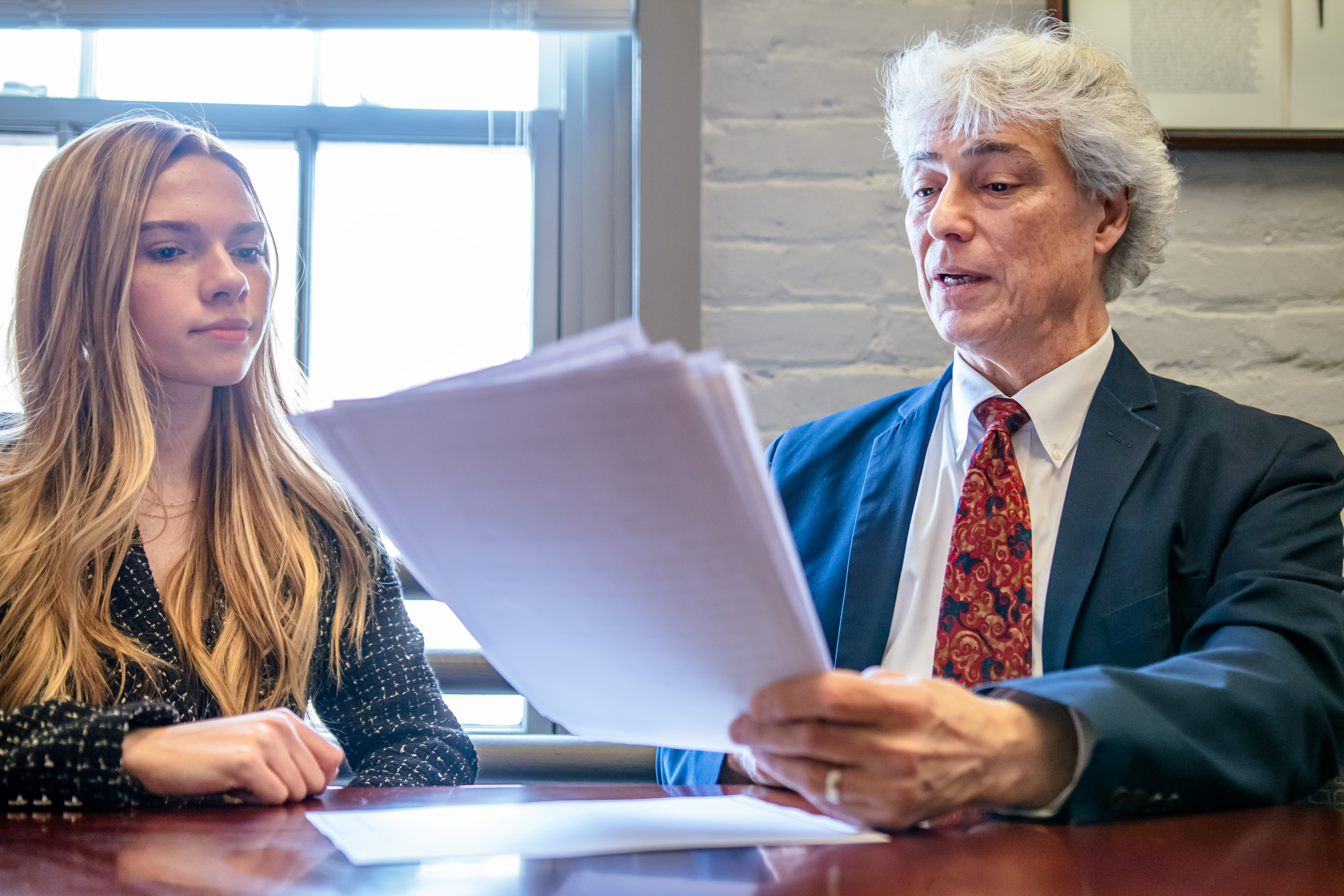 Kaylee White and Al Cardillo review a publication at the HCA office in Albany