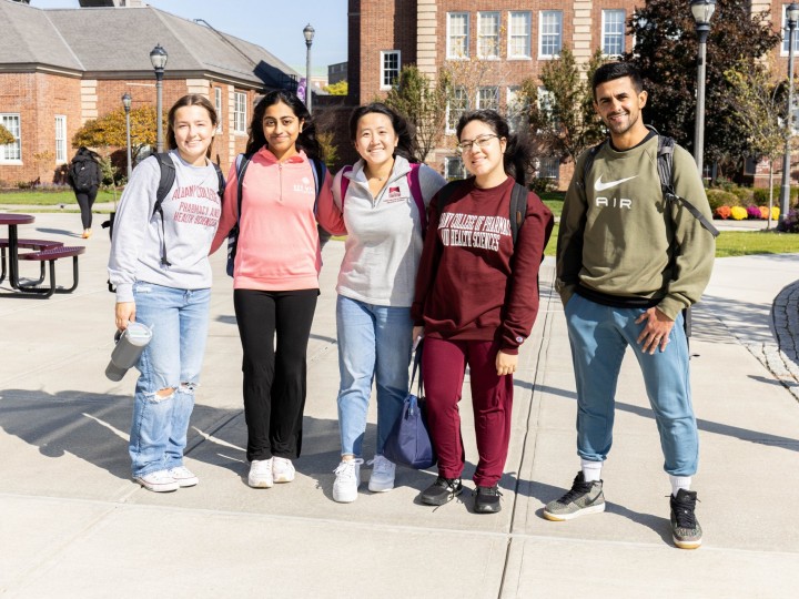 A group of ACPHS students stand together on campus