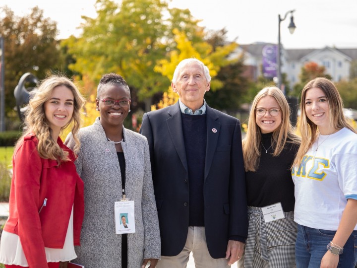 President Tofade stands with a group of students and alumni member at alumni weekend