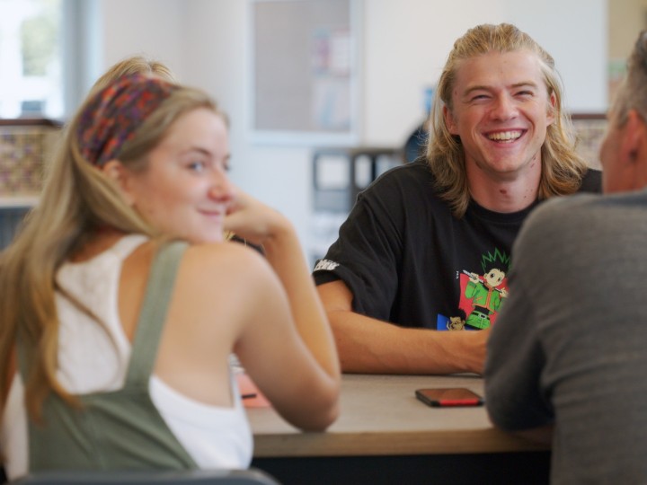smiling male student with a female in the cafeteria
