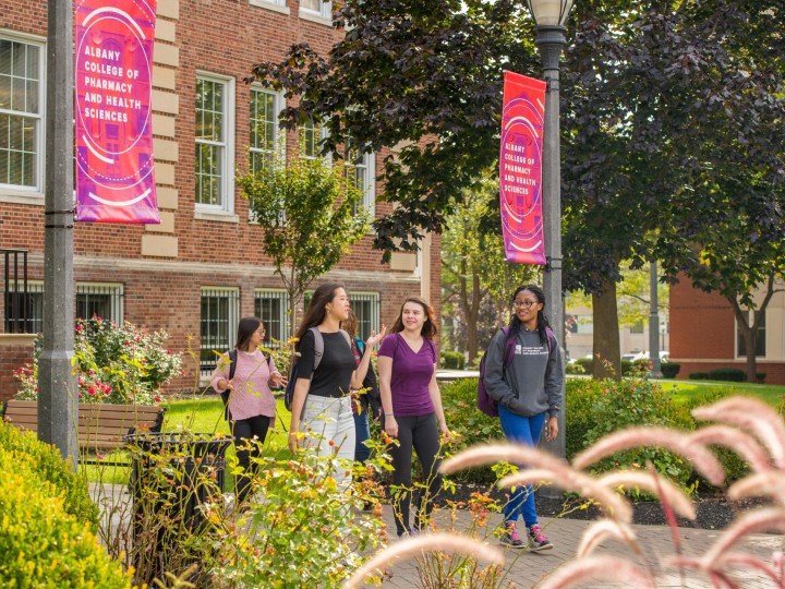 A group of students walk on ACPHS campus 