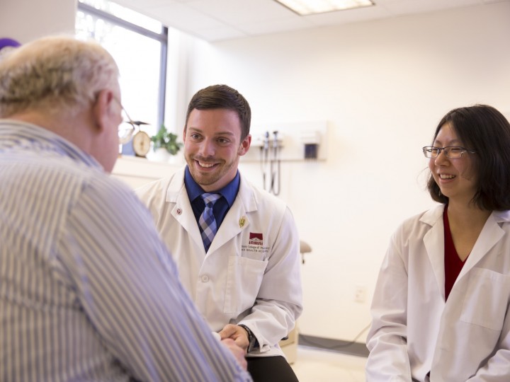 Two students consult patient during rotation program