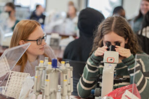 Students look into microscope during a session in Future of Healthcare Workshop 