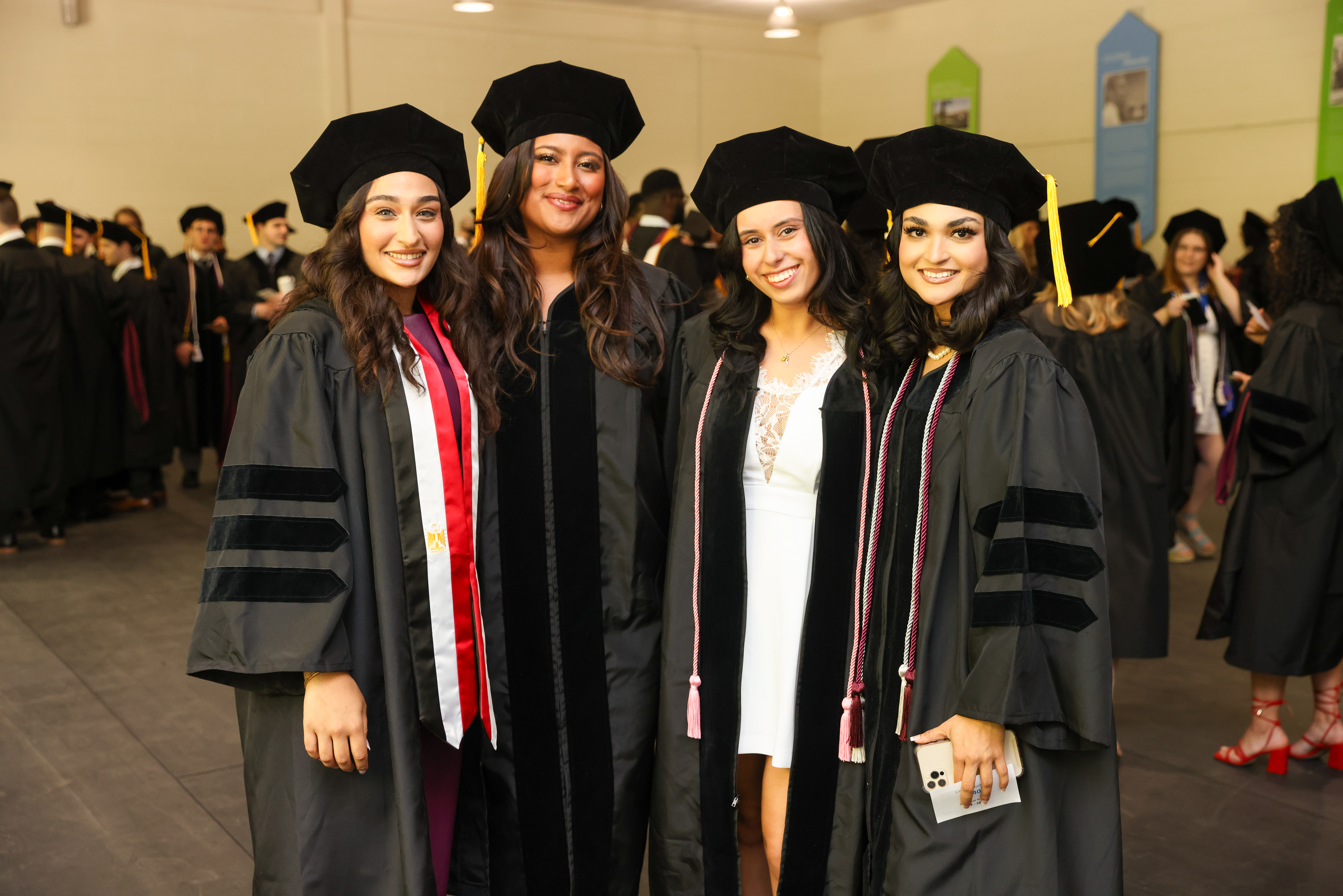 Student stand together in regalia as they get ready for Commencement