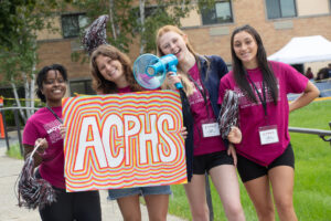 Orientation leaders hold ACPHS sign to greet families on move in day