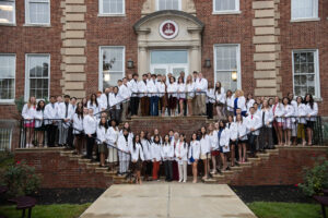 2023 White Coat Ceremony students stand on library stairs
