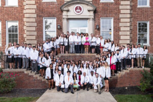 2024 White Coat Ceremony students stand on library stairs