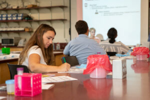 A student takes notes from instructor during future healthcare event