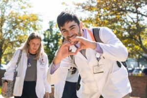 Two ACPHS students making a heart sign with their hands