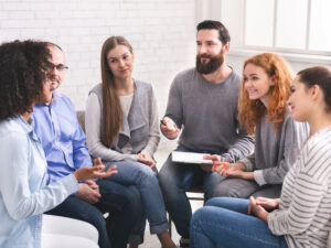 A group sits together in circle and has a conversation