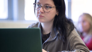 A student types on laptop in classroom