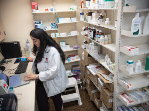A student types on laptop on the pharmacy counter