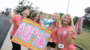 ACPHS Students welcome new students with ACPHS sign and pompoms