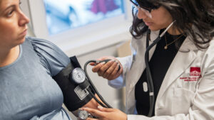 Anjali Kota takes blood pressure of patient in a rotation