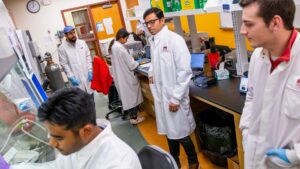 Dr Singh and Landon Tompson with students in lab