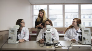 Front view of the students using the microscopes with instructor