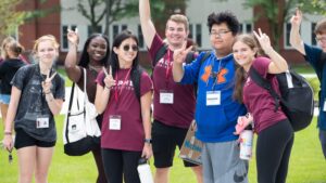 Happy students pose holding up peace sign