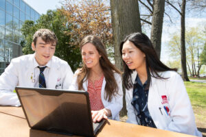 Dr. Cabral sits with pharmacy students outside during rotation