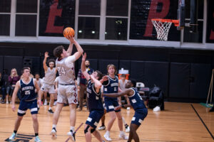 The ACPHS men's basketball team plays a game. A basketball player makes a hoop