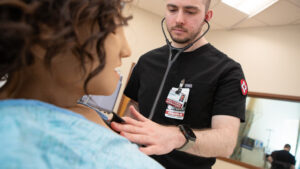 Nurse checks on patient in hospital bed