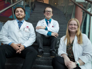 Pharmacy students sit on stairs in student center