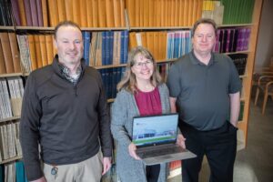 Rob Carter, Kate Wantuch and Ashley Hardesty stand in library