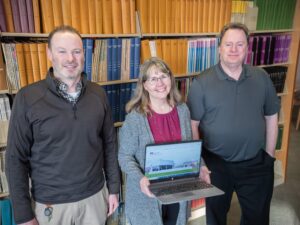 Rob Carter, Kate Wantuch and Ashley Hardesty stand in library