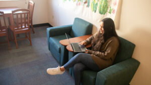 Student sits in dorm room on laptop