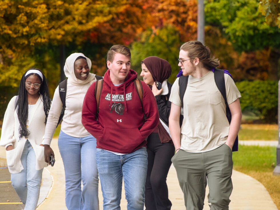 Students walk and laugh together on campus 