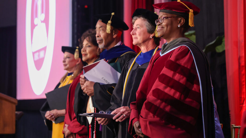Toyin Tofade stands with Board of Trustees and guests at Inauguration