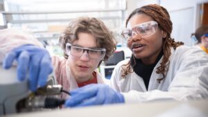 Two biotechnology students rewire cords in lab