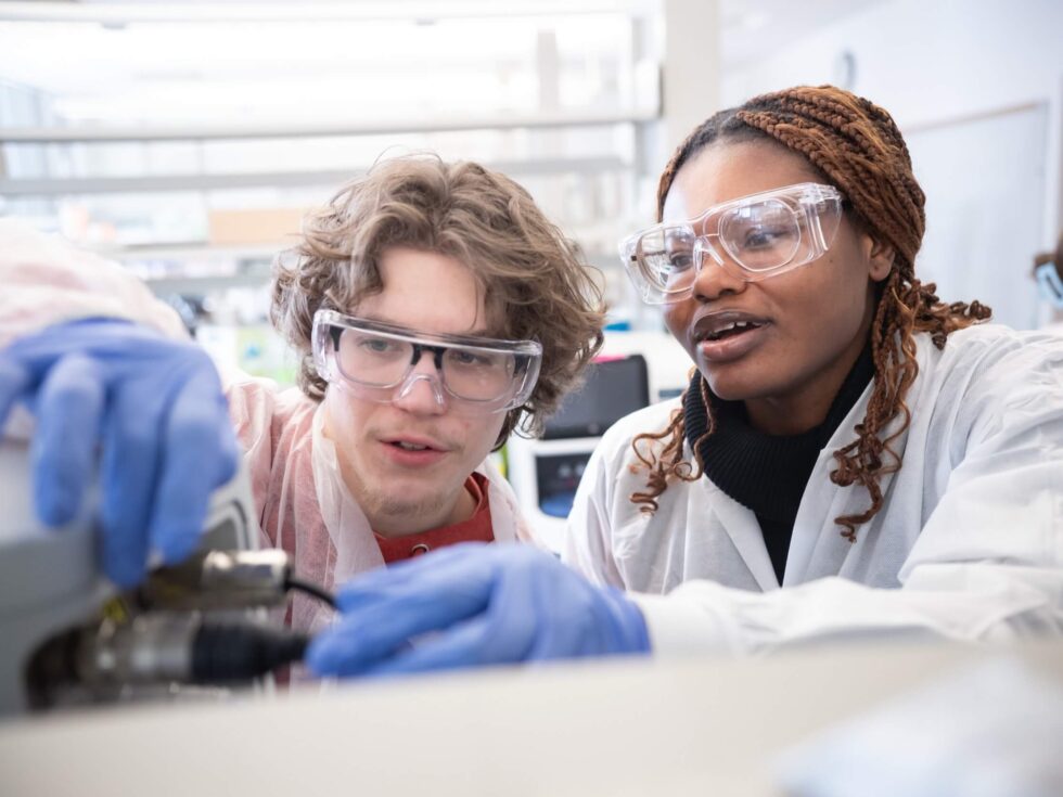 Two biotechnology students rewire cords in lab