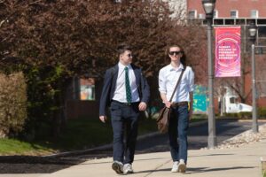 Two dressed up students walk on campus