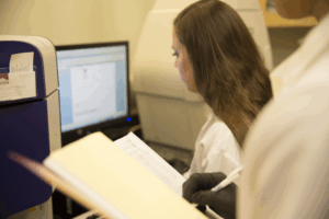 A student examines data and recording findings in journal
