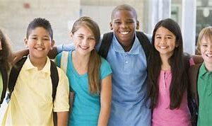 A group of young students stand together with backpacks