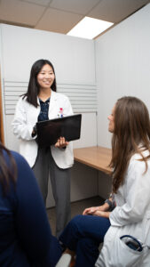Student holds a laptop while to take notes during a rotation