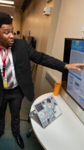 Deondre points to research poster