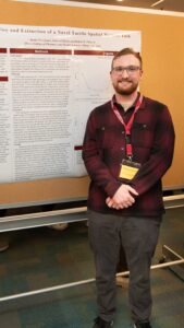 Justin Morehouse stands in front of research poster