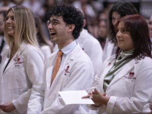 Students smile in crowd at white coat ceremony