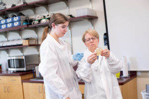 Professor Parent helps a CLS student examine a slide
