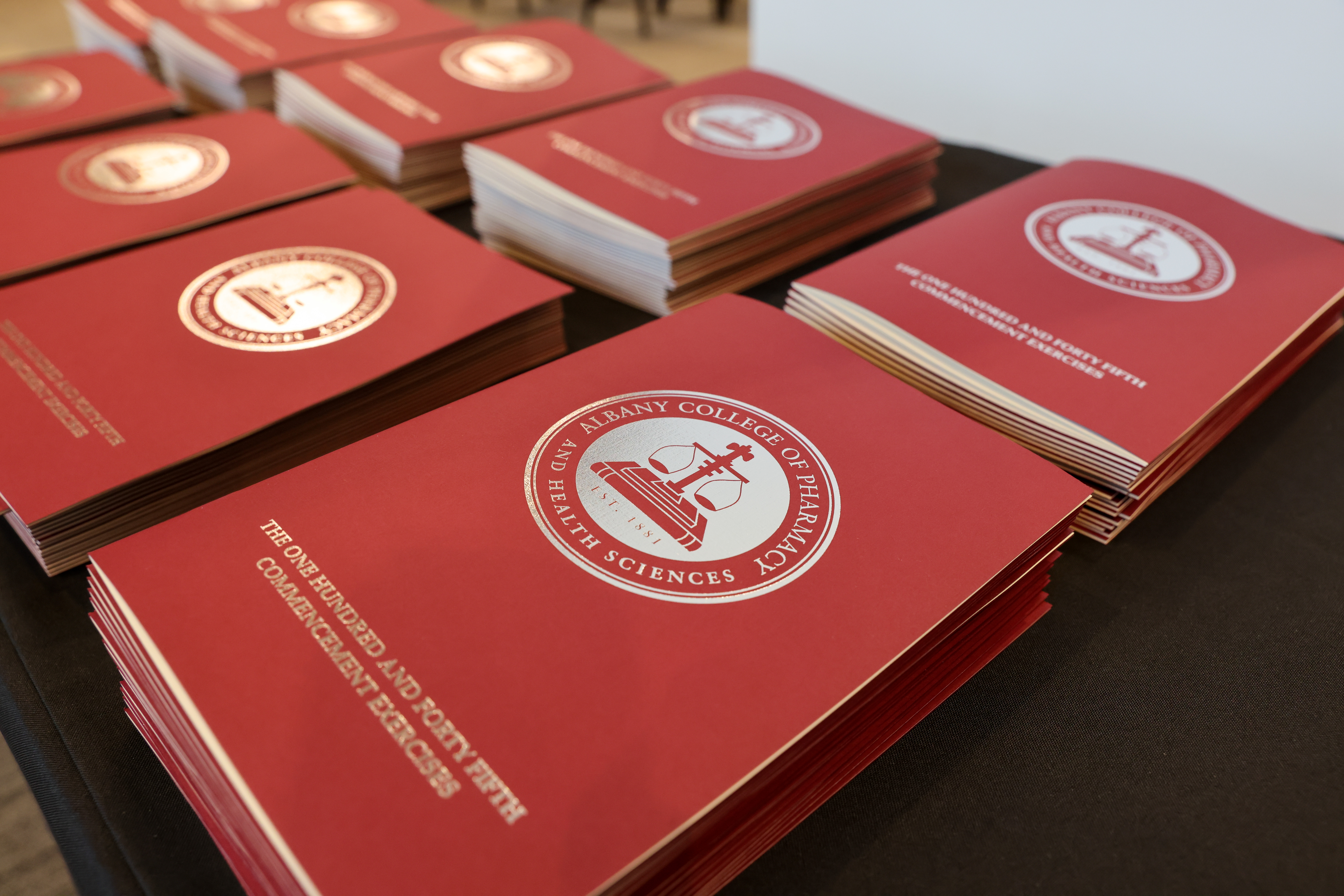 A stack of maroon Commencement programs on a table