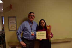 Dr. Micheal Brodeur and Dr. Ugene Sano holding flowers and an award certificate