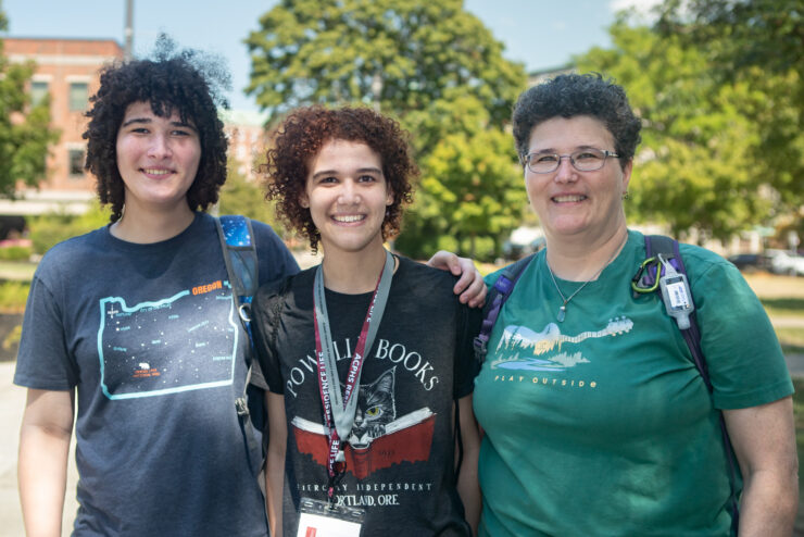 First-year student stands outside with family members at orientation 2025