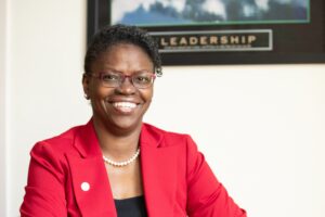 Headshot of Toyin Tofade in red jacket with black cami