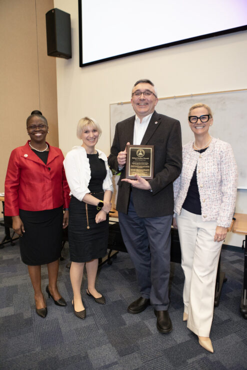 President Tofade, Katie Cardone and Elena Umland celebrate Michael Brodeur's 25 year anniversary