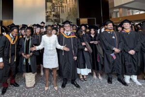 ACPHS President Toyin Tofade stands with the Class of 2026 at Commencement