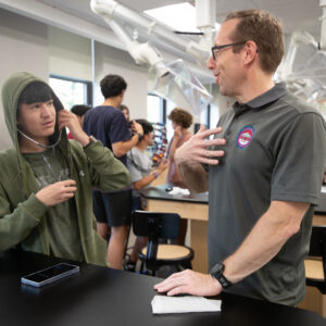 Eric Yager works with student during summer camp